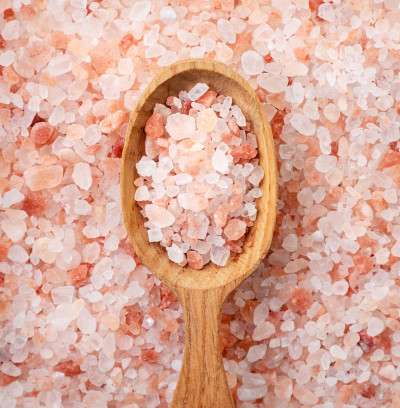 盐背景的勺子里的喜马拉雅粉盐。俯视图
