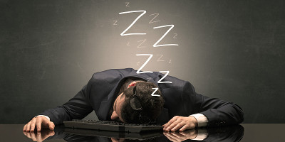 一个商人在办公室的键盘上睡着了