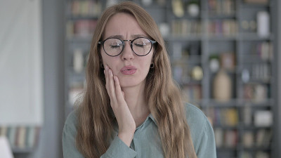 生病的女人在办公室里牙痛的肖像