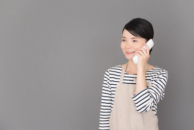 一个穿着围裙的女人站在灰色背景前