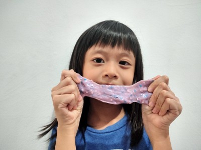 亚洲孩子在白色背景上玩橡皮泥