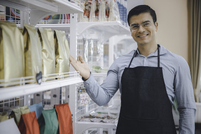 企业家，男企业家，戴眼镜，在便利店卖产品
