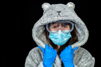 病毒。穿着浴袍的女人戴着防护手套和医用口罩。