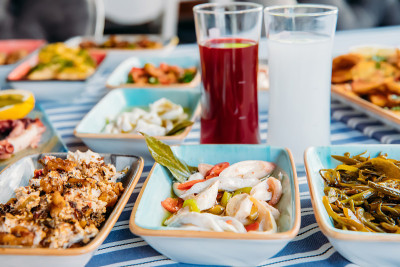 烤鱼、沙拉和蔬菜。海鲜，烤肉，meze, raki, ouzo，开胃菜和沙拉在希腊或土耳其鱼餐厅的桌