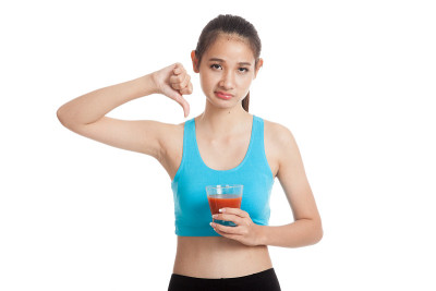 美丽健康的亚洲女孩讨厌番茄汁