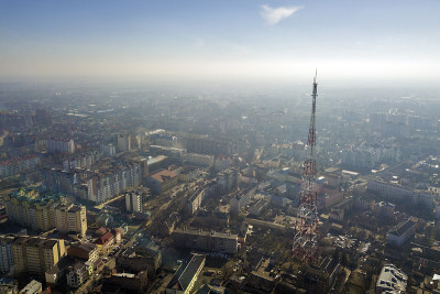 鸟瞰图的现代城市城市的雾景观与高电视塔在明亮的蓝色天空复制空间背景在黎明。无人机摄影。
