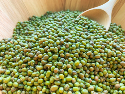 许多绿豆或绿豆在木碗和木匙舀
