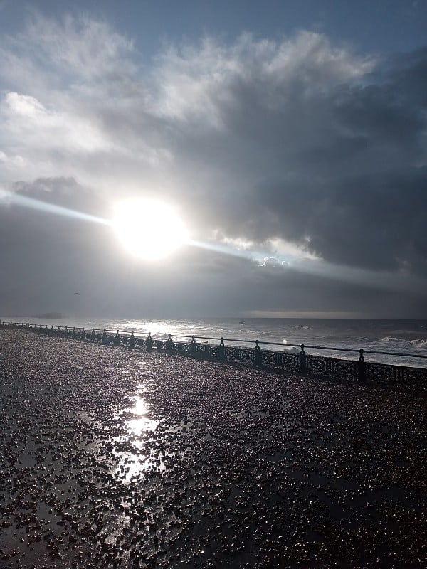 太阳在布赖顿海滨风暴后与散步英国