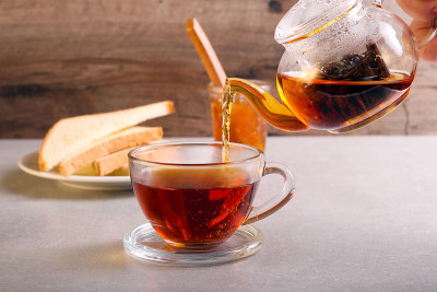 将红茶倒入玻璃杯中