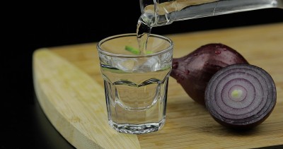 在切菜板上用小酒杯倒伏特加酒和洋葱