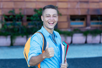 Laughing blond male student walking to university