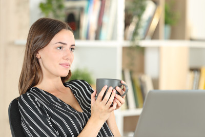 放松的女人拿着咖啡杯在家沉思