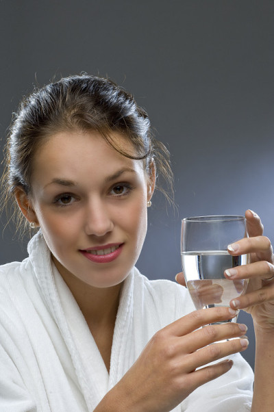 漂亮的黑发女子拿着一杯水
