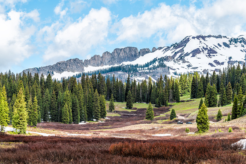 2019年初夏，山顶的Butte Kebler Pass雪和干燥的岩石山与草地上的松树