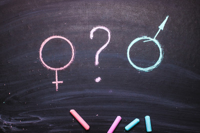 用粉笔在黑板上画出一个男人和一个女人的形象。