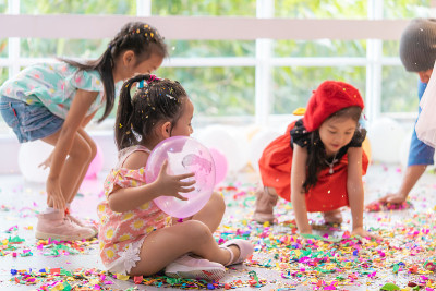 孩子们在孩子聚会上玩，扔纸和气球