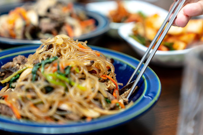 Japchae是一种传统的韩国食物，由煮豆丝、炒蔬菜和肉丝混合而成。