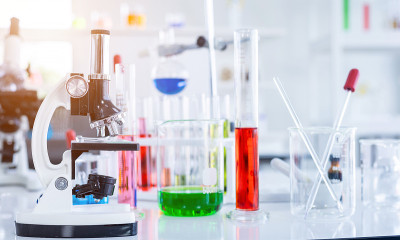 显微镜和试管与实验室玻璃器皿在实验室背景，研究和科学概念