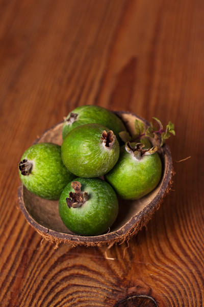 椰壳壳上的青feijoa木背景。成熟的热带水果，生的素食。维生素c拷贝空间。