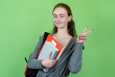 笑着的英国女学生拿着文件和背包
