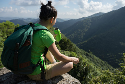 成功的女性徒步旅行者在徒步旅行中饮用水