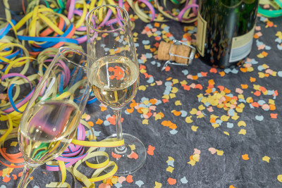 石板上装饰着狂欢节的香槟酒杯和酒瓶