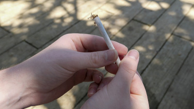 某人用散装烟草卷完一支烟