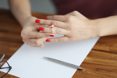 女人的手从手指上取下结婚戒指。