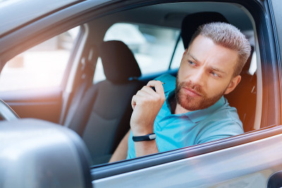 英俊的男子检查道路前启动汽车