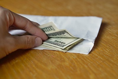 男手打开白色信封，上面印着美元(USD)