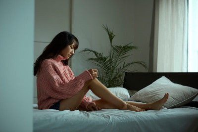 一个年轻的亚洲女人正在床上休息