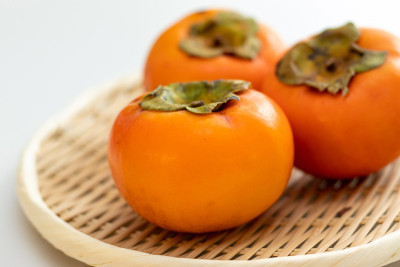 美味的柳橙柿子放在竹篓里