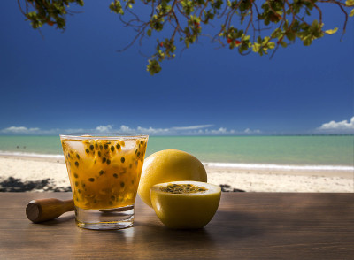 新鲜饮料与百香果caipiinha在海滩的背景