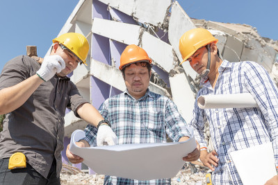工程师建筑师和工人操作控制拆除旧建筑。