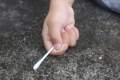 小男孩手里拿着白耳朵清洁剂
