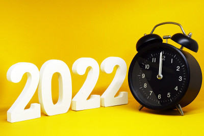 2021年到2022年新年倒计时，数字2022木制字与复古黑色时钟(0时钟)的黄色背景色-节日庆祝概