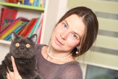 女孩戴着医用口罩，手里拿着英国猫品种。预防猫感染弓形虫。