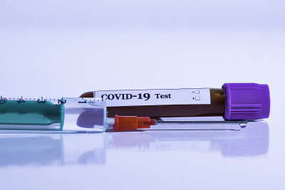 有covid-19检测标记的血液样本管和有疫苗的注射器。