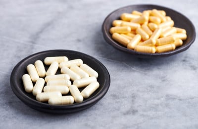 α硫辛酸和辅酶Q10胶囊。免疫系统的支持。健康膳食补充的概念。明亮的石头背景。关闭了。