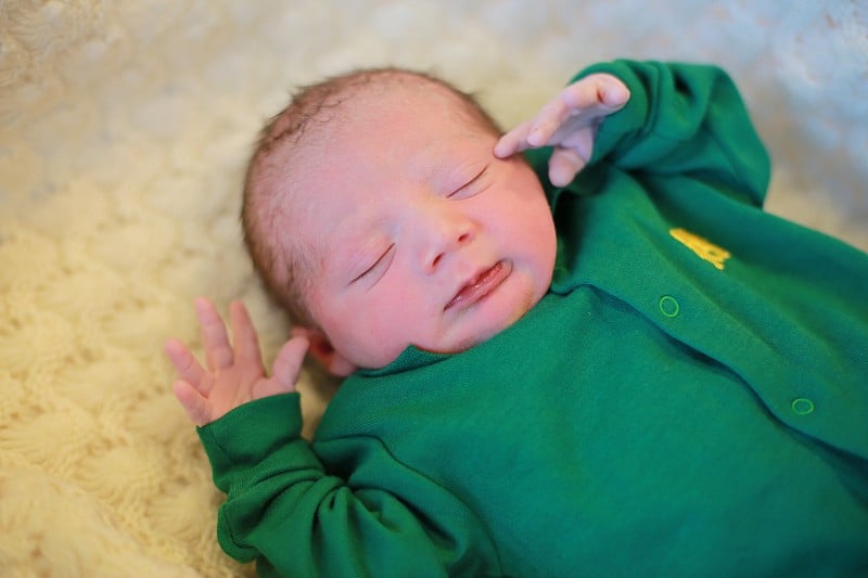 New Born Baby Boy With Green Baby Suit on a White 