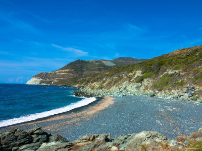 鸟瞰图黑色卵石海滩，Nonza，地中海灌木丛，山坡靠近海岸。科西嘉岛的科斯角半岛。海岸线。法国