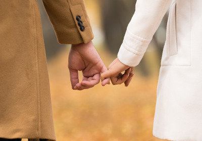幸福的夫妇抱着小指，秋天的场景在公园