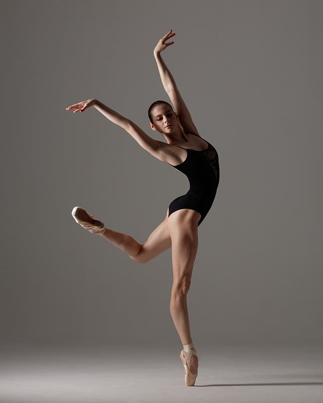 Young beautiful ballet dancer is posing in studio