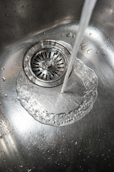 银金属厨房水槽近距离拍摄与自来水附近的排水管俯视图