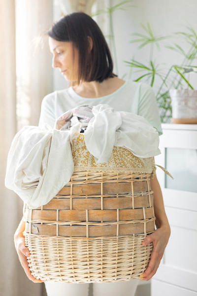 白人妇女整理脏衣服篮，在家里洗衣服