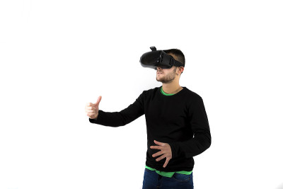 年轻愉快和现代胡子的人戴着vr眼镜享受虚拟现实与模拟器持有虚拟的东西
