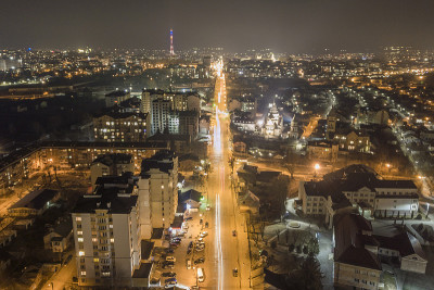 宽阔的夜晚全景，空中俯瞰现代城市。景象明亮的高楼大厦，照亮的街道，高电视塔在黑暗的天空复制空间背景。