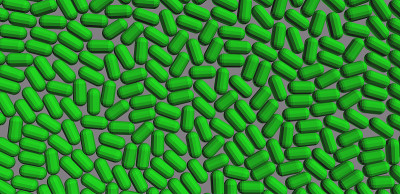 Green plastic polymer granules on gray background.