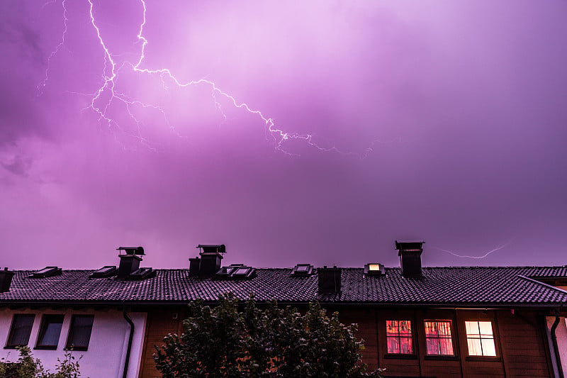 夜间的雷雨:建筑物屋顶上方的闪电