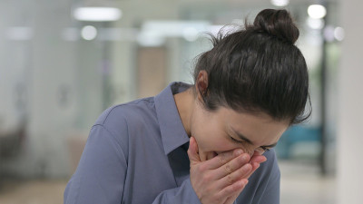 年轻的印度女人打喷嚏的肖像